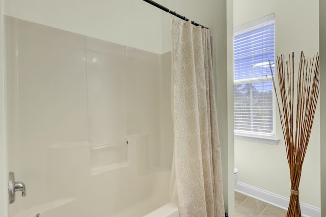 bathroom featuring shower / bath combo, tile patterned flooring, baseboards, and toilet