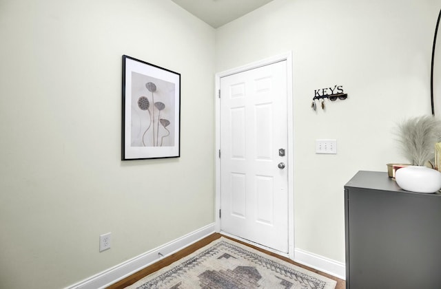 entrance foyer with baseboards and wood finished floors