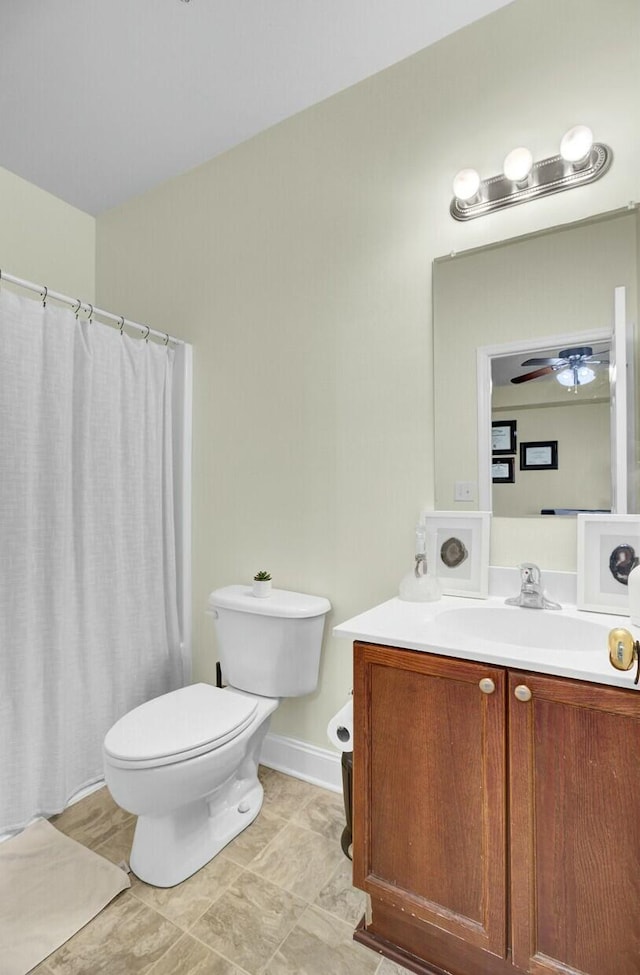 full bath featuring a shower with shower curtain, toilet, a ceiling fan, vanity, and baseboards