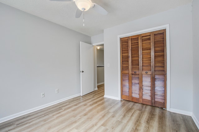 unfurnished bedroom featuring ceiling fan, a textured ceiling, a closet, and light hardwood / wood-style floors