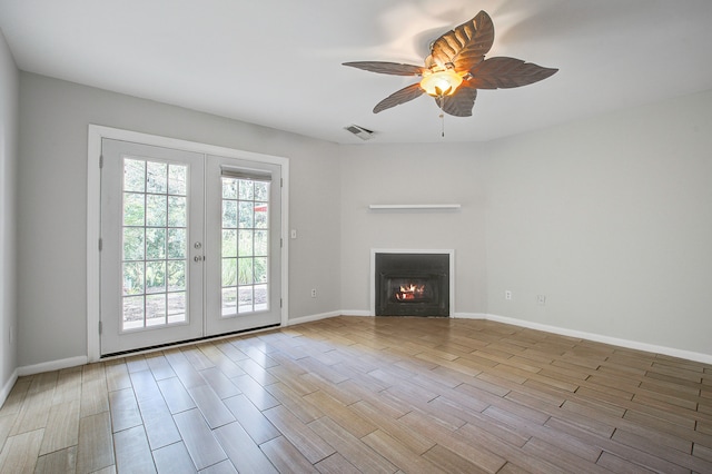 unfurnished living room featuring french doors and ceiling fan