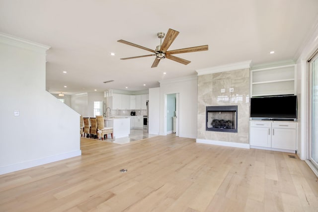 125 Oak Bay Dr, Georgetown, SC 29440 - unfurnished living room with ornamental molding, ceiling fan, light wood-style flooring, recessed lighting, and a tiled fireplace