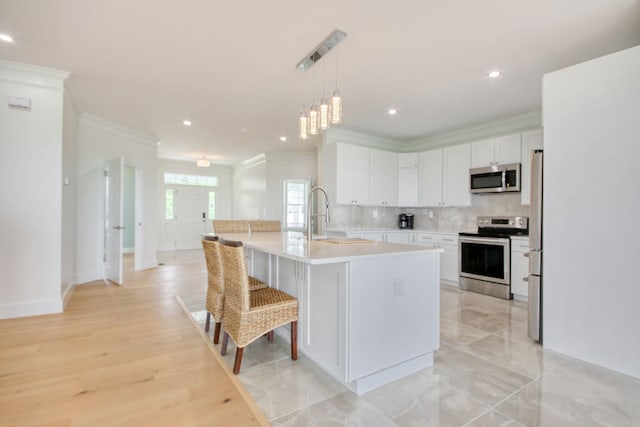 125 Oak Bay Dr, Georgetown, SC 29440 - kitchen with appliances with stainless steel finishes, ornamental molding, light countertops, white cabinetry, and backsplash