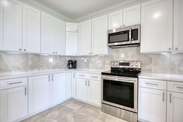 125 Oak Bay Dr, Georgetown, SC 29440 - kitchen featuring stainless steel appliances, light countertops, white cabinetry, decorative backsplash, and ornamental molding