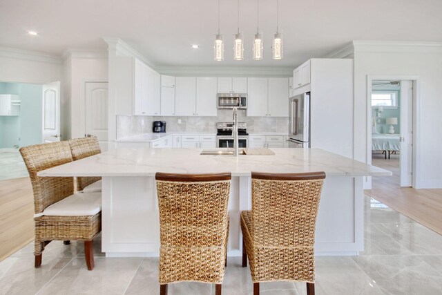 125 Oak Bay Dr, Georgetown, SC 29440 - kitchen featuring stainless steel appliances, crown molding, white cabinetry, light stone counters, and decorative backsplash