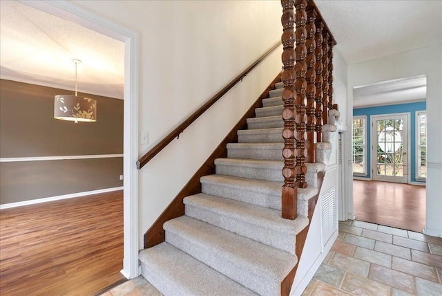 staircase with a textured ceiling