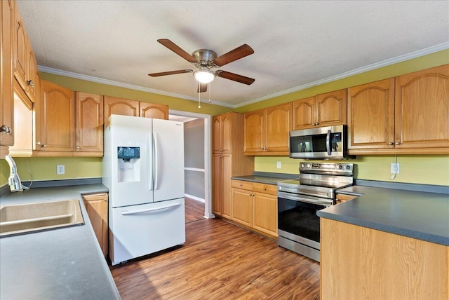 kitchen with sink, ornamental molding, stainless steel appliances, and wood-type flooring