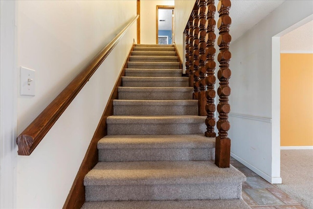 stairway featuring carpet flooring