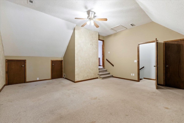 bonus room with light colored carpet, lofted ceiling, and a textured ceiling