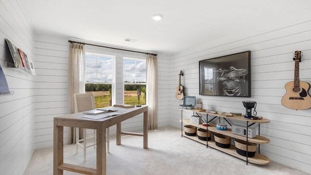 carpeted home office featuring wood walls