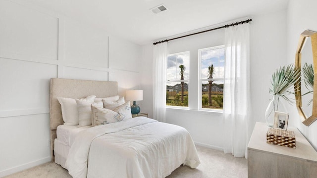 bedroom with light colored carpet and baseboards