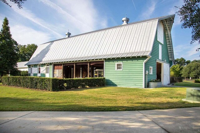 back of property featuring a yard, a gambrel roof, and metal roof
