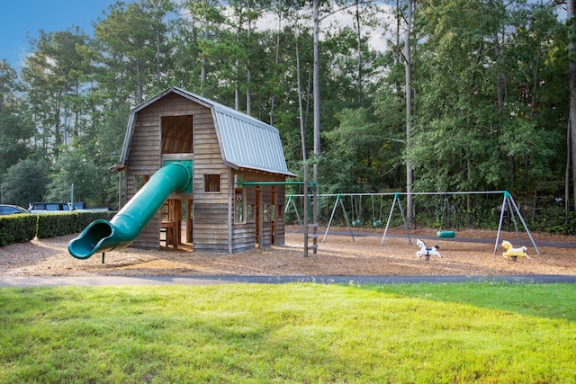 communal playground featuring a lawn and view of scattered trees