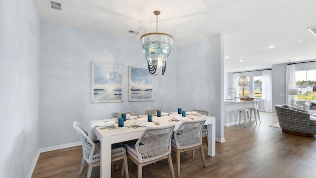 dining area with a chandelier, wood finished floors, baseboards, and recessed lighting