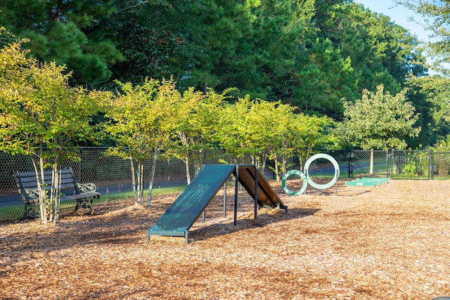 view of jungle gym featuring fence and a dog friendly area