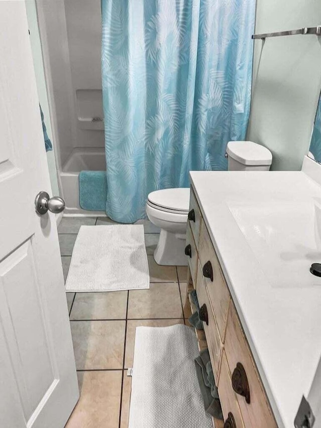 full bathroom with shower / tub combo, vanity, toilet, and tile patterned floors