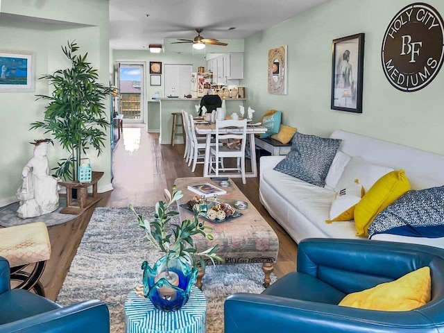 living room with a ceiling fan and wood finished floors