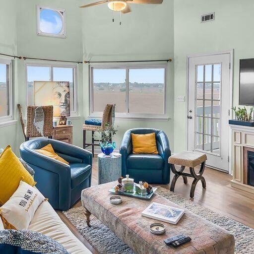 living room featuring a healthy amount of sunlight, visible vents, a fireplace, and wood finished floors