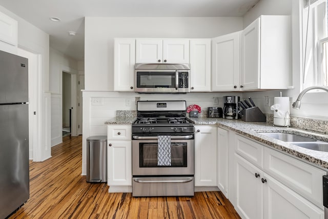 170 Spring St, Charleston, SC 29403 - kitchen featuring stainless steel appliances, wood finished floors, white cabinets, and recessed lighting