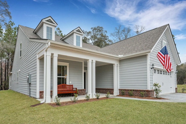 view of front of home with a garage, a front yard, and covered porch