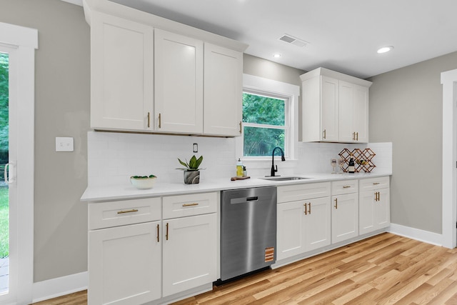 6305 Lucille Dr, North Charleston, SC 29406 - kitchen with stainless steel dishwasher, a sink, light countertops, baseboards, and light wood-style floors