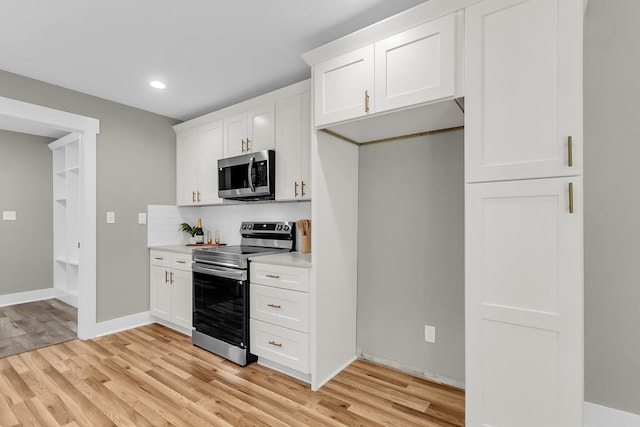 6305 Lucille Dr, North Charleston, SC 29406 - kitchen featuring stainless steel appliances, light countertops, light wood-style flooring, tasteful backsplash, and white cabinets