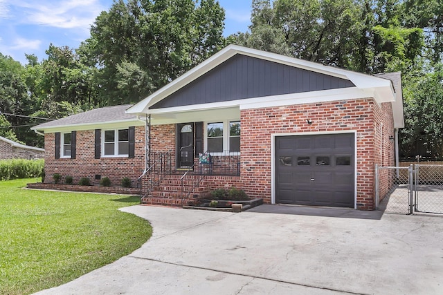 6305 Lucille Dr, North Charleston, SC 29406 - view of front facade featuring a garage, brick siding, driveway, a gate, and a porch