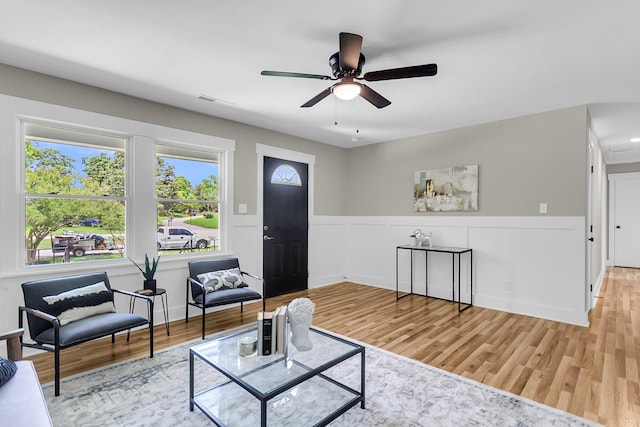 6305 Lucille Dr, North Charleston, SC 29406 - living room with wood finished floors, a ceiling fan, and wainscoting