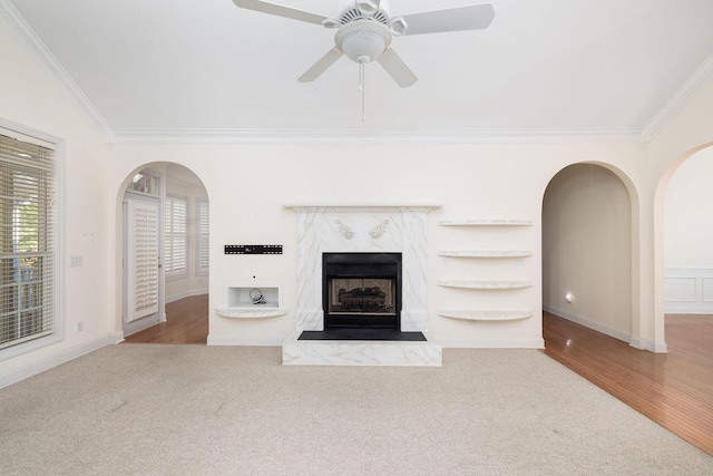 unfurnished living room with a fireplace, crown molding, hardwood / wood-style floors, and ceiling fan