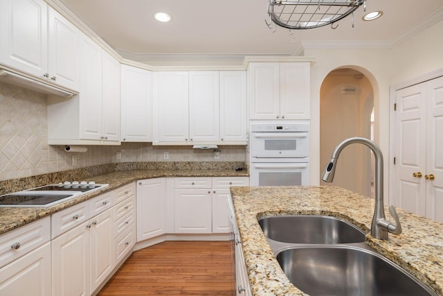 kitchen with light hardwood / wood-style floors, white cabinetry, and sink