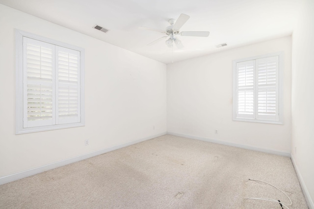 empty room featuring light colored carpet and ceiling fan