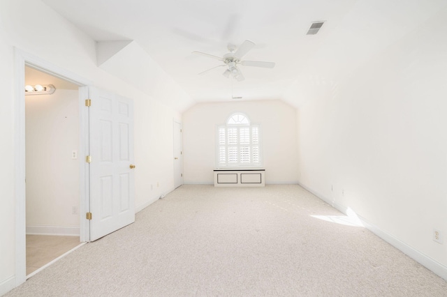 interior space featuring ceiling fan, lofted ceiling, and light carpet