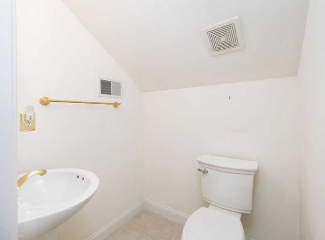 bathroom featuring tile patterned floors, sink, vaulted ceiling, and toilet