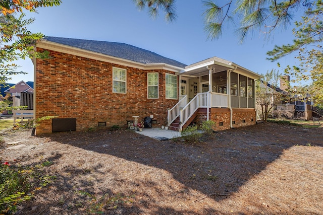 rear view of property featuring a sunroom