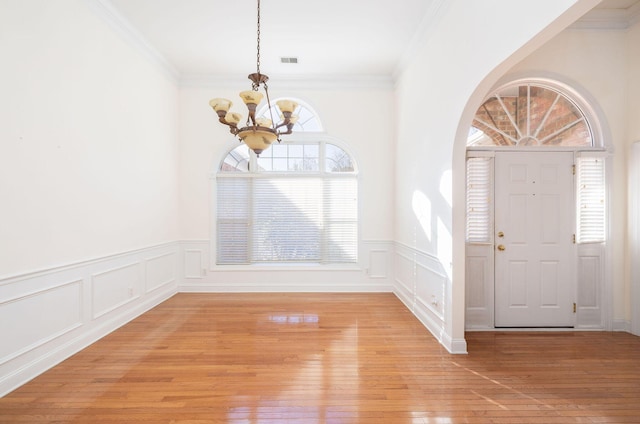 foyer entrance featuring a chandelier, light hardwood / wood-style flooring, and ornamental molding