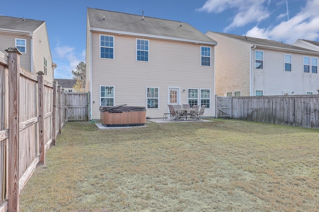 back of house with a yard, a patio, and a hot tub