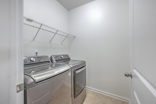 laundry area with separate washer and dryer and light tile patterned floors