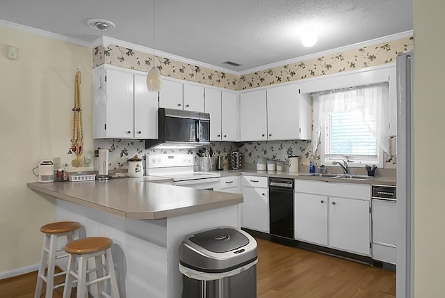 kitchen featuring white cabinets, decorative light fixtures, a sink, black microwave, and white range with electric cooktop