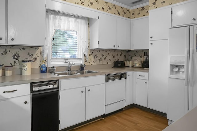 kitchen with light countertops, white appliances, white cabinets, and a sink