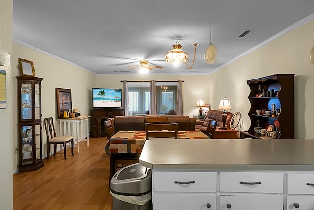 living room featuring ceiling fan, crown molding, and light hardwood / wood-style flooring