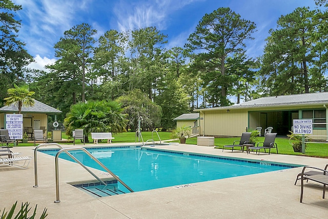 view of swimming pool with a patio and a lawn