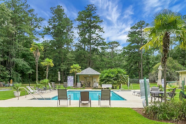 view of pool with a patio and a lawn