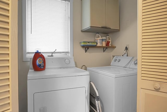 washroom featuring separate washer and dryer and cabinet space