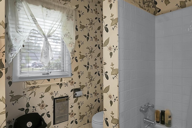 bathroom with toilet, wallpapered walls, shower / bath combination, and heating unit