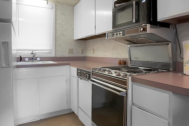 kitchen with white cabinetry, white range with gas cooktop, sink, and black microwave