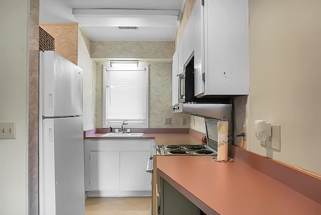 kitchen featuring white fridge and sink