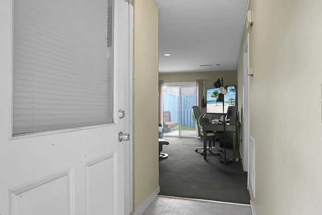 hall with baseboards and light colored carpet