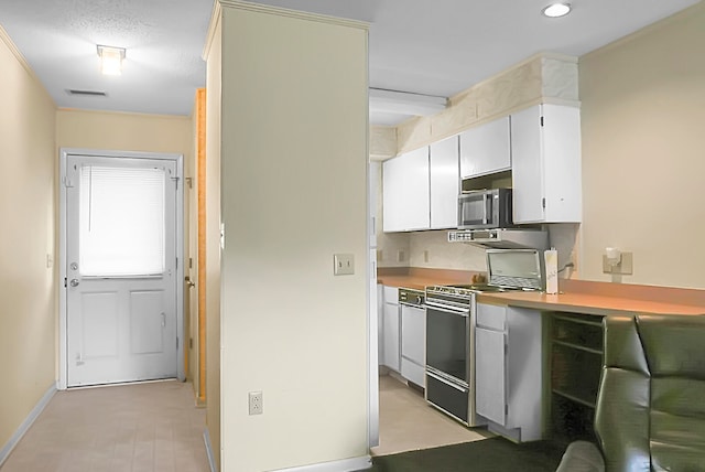 kitchen featuring stainless steel appliances, backsplash, and white cabinets