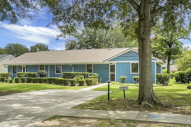 ranch-style home with driveway and a front yard