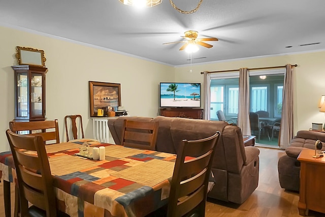 dining space featuring hardwood / wood-style flooring, crown molding, and ceiling fan